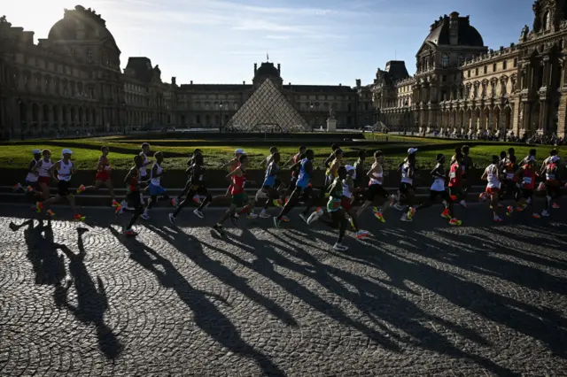 The marathon runners going past the Louvre