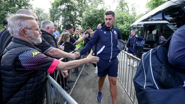 Bromley players greet fans after getting off the team bus