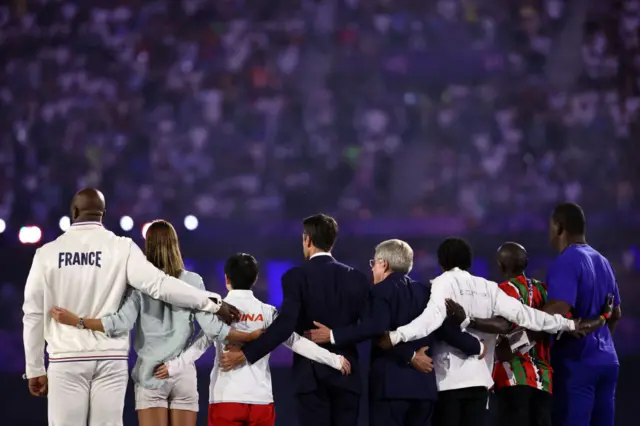 President of the Paris 2024 Olympics and Paralympics Organising Committee (Cojo) Tony Estanguet (C-L) and International Olympic Committe (IOC) President Thomas Bach (C-R) stand with athletes as the Olympic anthem is played during the closing ceremony