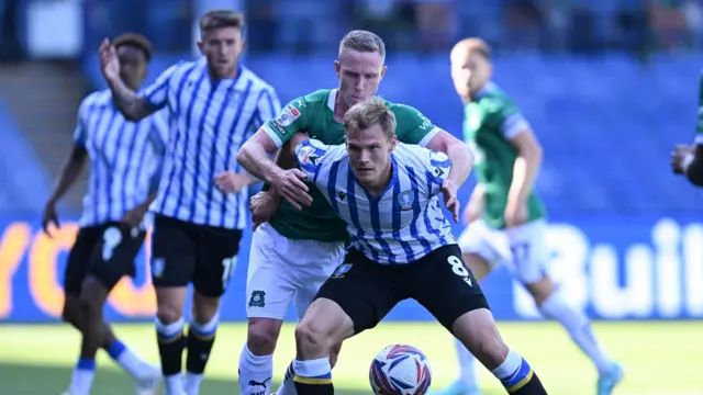 Sheffield Wednesday player holds off a tackle