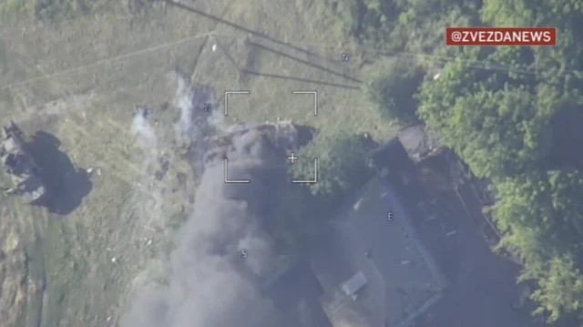 An aerial shot of an attack is seen with smoke plumes overhead