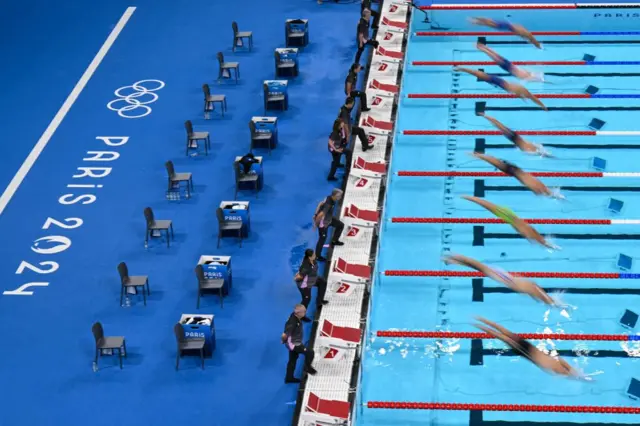 Swimmers dive as they take the start of a heat of the men's 50m freestyle swimming event during the Paris 2024 Olympic Games at the Paris La Defense Arena