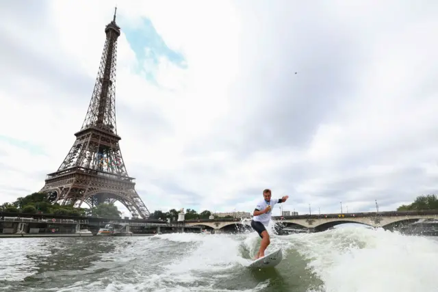 Gold medallist France's Kauli Vaast of Team France surfs in the Seine river with the Eiffel tower in the background during the Paris 2024 Olympic Games