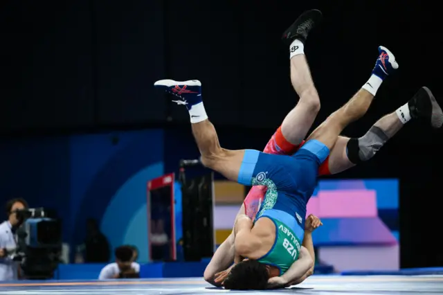 US' Spencer Richard Lee (red) wrestles Uzbekistan's Gulomjon Abdullaev (Blue) in their men's freestyle 57kg wrestling semi-final match at the Champ-de-Mars Arena during the Paris 2024 Olympic Games