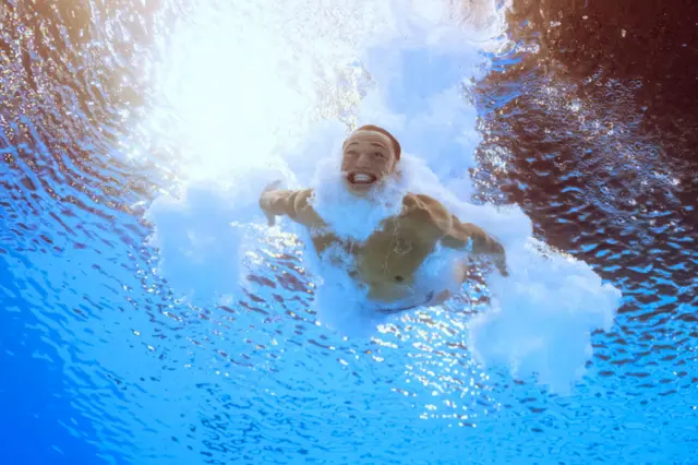 n underwater view shows Britain's Jordan Christopher Houlden competing in the men's 3m springboard diving preliminary during the Paris 2024 Olympic Games at the Aquatics Centre in Saint-Denis