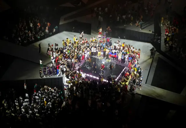 Athletes are seen on stage as Phoenix performs during the closing ceremony.