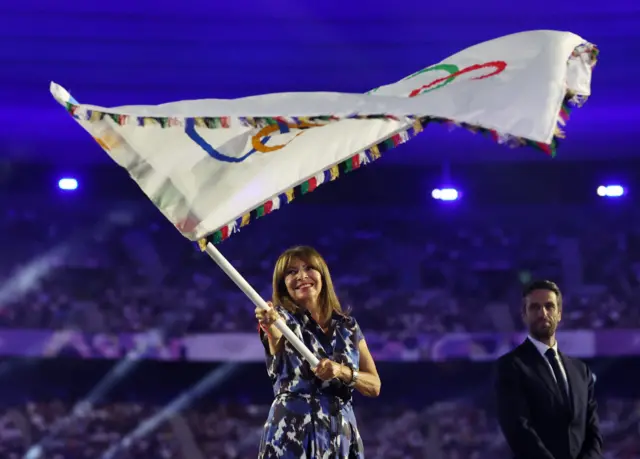 Paris mayor Anne Hidalgo waves the Olympic flag during the closing ceremony