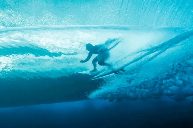 France's Joan Duru gets into the barrel in the 2nd heat of the men's surfing round 1, during the Paris 2024 Olympic Games, in Teahupo'o, on the French Polynesian Island of Tahiti