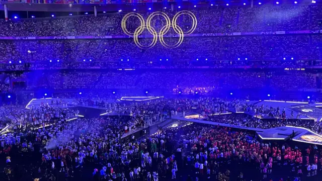 Athletes climb onto a stage in the Stade de France