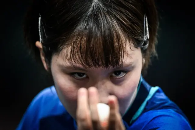 Japan's Miu Hirano eyes the ball as she prepares to serve to India's Manika Batra during their women's table tennis singles round of 16 at the Paris 2024 Olympic Games at the South Paris Arena