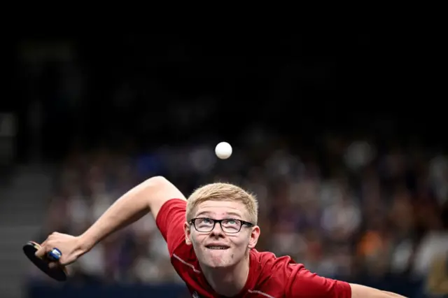 France's Felix Lebrun eyes the ball as he prepares to serve to India's Harmeet Desai during their men's table tennis singles round of 64 at the Paris 2024 Olympic Games at the South Paris Arena