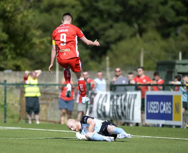 Reds captain Ryan Curran hurdles Ports keeper Aaron McCarey