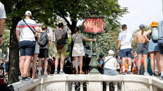 Parisians stand on a wall to watch sporting action