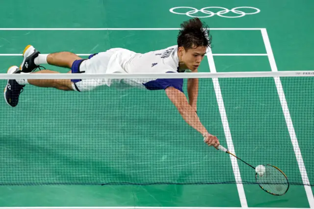 US' Vinson Chiu dives after the shuttle during a relay in his mixed doubles badminton group stage match against China during the Paris 2024 Olympic Games at Porte de la Chapelle Arena