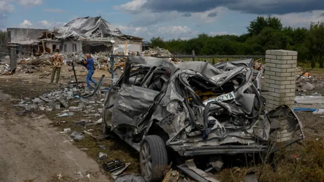 Men are seen at a site of a residential building heavily damaged during a Russian missile strike, amid Russia's attack on Ukraine, in the village of Rozhivka in Kyiv region, Ukraine August 1