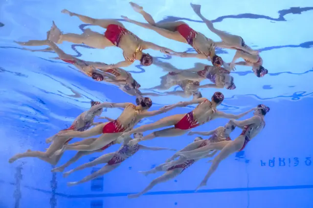 An underwater view shows Team China competing in the team acrobatic routine of the artistic swimming event during the Paris 2024 Olympic Games at the Aquatics Centre in Saint-Denis