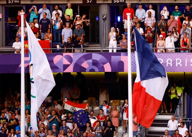 The Olympic flag and the flag of France are raised during the closing ceremony