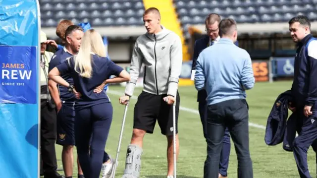 Sam McClelland appears on crutches at Rugby Park