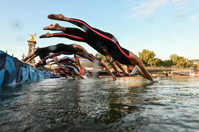 Athletes dive into the Seine river as they take the start of the women's 10km marathon swimming final at the Paris 2024 Olympic Games at Pont Alexandre III bridge in Paris