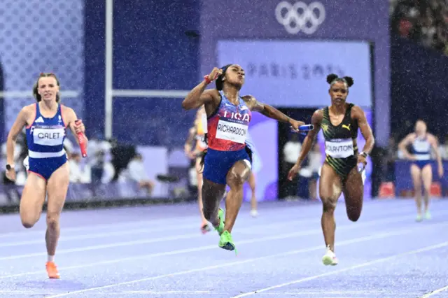 US' Sha'Carri Richardson crosses the finish line to win ahead of France's Chloe Galet and Jamaica's Tia Clayton in the women's 4x100m relay final of the athletics event at the Paris 2024 Olympic Games at Stade de France