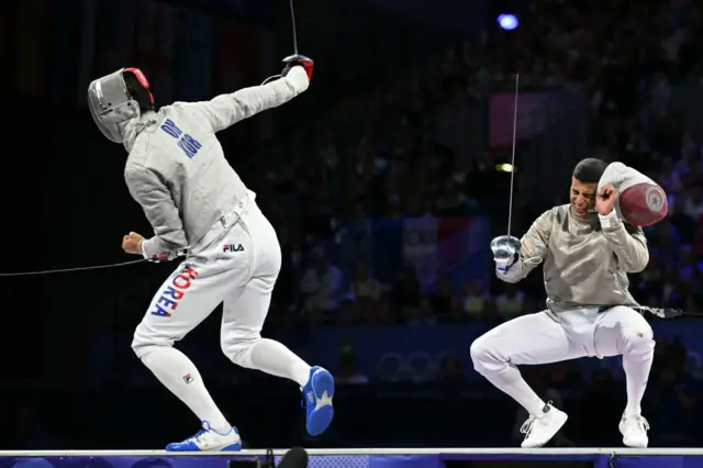 South Korea's Oh Sang-uk (L) and Tunisia's Fares Ferjani compete in the men's sabre individual gold medal bout during the Paris 2024 Olympic Games at the Grand Palais