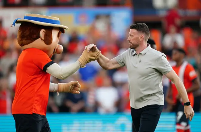 Luton Town manager Rob Edwards shakes hands with Hatters mascot Happy Harry