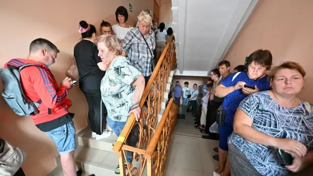 People queue to receive humanitarian aid intended for residents of the Kursk region, who were evacuated following an incursion of Ukrainian troops, in the course of Russia-Ukraine conflict in Kursk, Russia August 11, 2024.