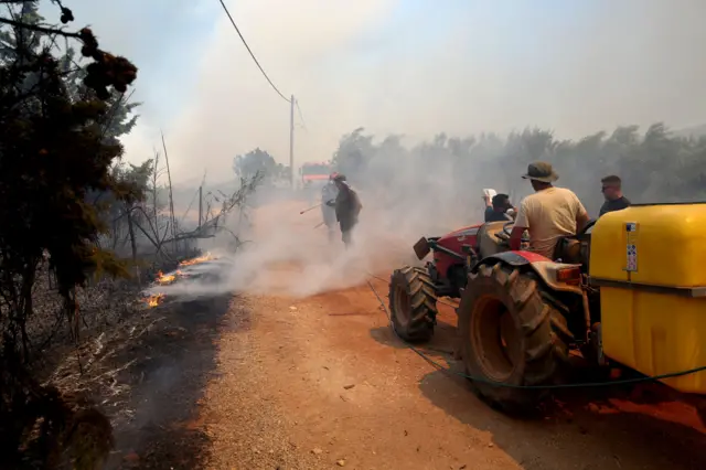 Residents try to extinguish a wildfire in Marathon, northeast Attica