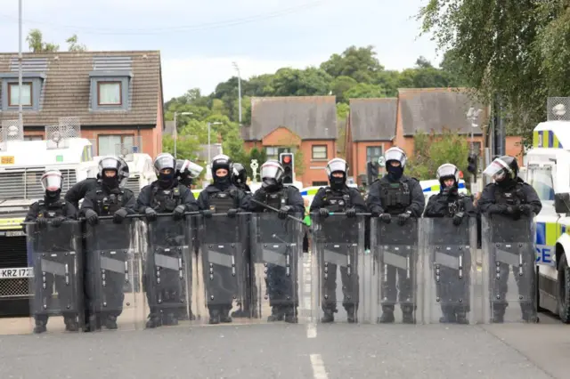 Riot police form a line in Belfast on a street