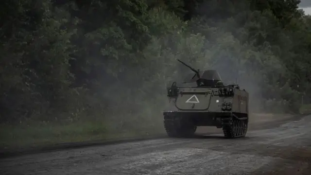 Ukrainian servicemen ride an armoured personnel carrier,