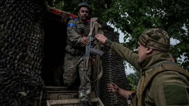 Ukrainian servicemen get out of an armoured personnel carrier