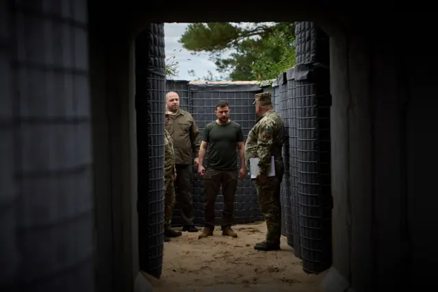 Ukrainian President Volodymyr Zelensky (C) inspecting the construction of fortifications at an undisclosed location, during his working visit in the Volyn region, Ukraine