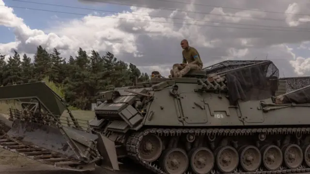 Ukrainian servicemen operate an armoured military vehicle in the Sumy region, near the border with Russia, on August 13