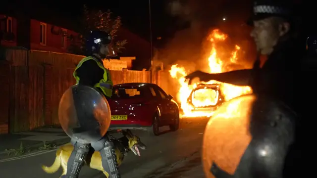 A police car burns as officers are deployed on the streets of Hartlepool