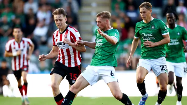 Cheltenham and Plymouth players challenge for the ball