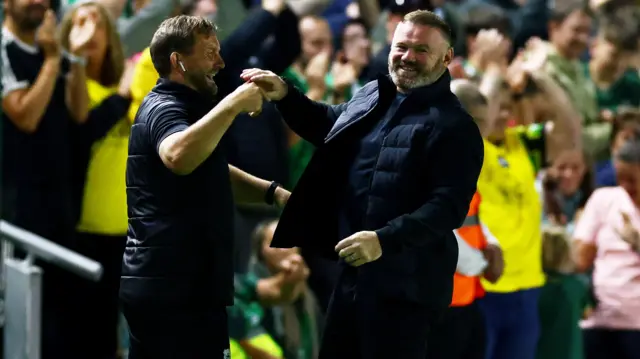 Wayne Rooney celebrates a goal with his coaching staff