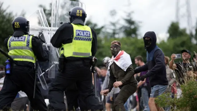 Riot police clash with anti-migration protesters outside a hotel housing asylum seekers near Rotherham