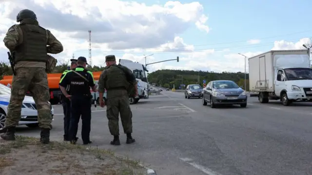 Russian police officers and military personnel stand guard at a checkpoint on the city outskirts, after a tight security regime was imposed in the region due to an incursion of Ukrainian troops, in the course of Russia-Ukraine conflict in Belgorod, Russia August 12, 2024.