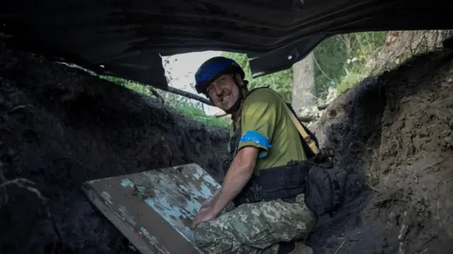 A serviceman shelters from shelling