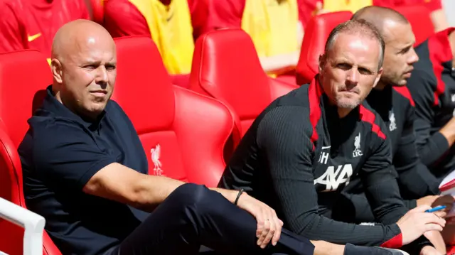 Liverpool manager Arne Slot sat in the dugout with his coaching staff