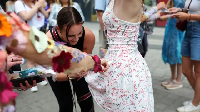 Woman signs fan's dress