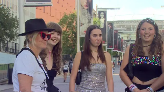 Taylor Swift fans dressed in colourful and sparkly clothes outside Wembley stadium