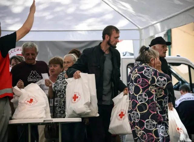 Displaced people receive humanitarian aid at a Russian Red Cross distribution point in Kursk