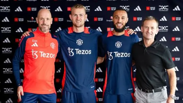 Matthijs de Ligt and Noussair Mazraoui of Manchester United pose with Manager Erik ten Hag and Sporting Director Dan Ashworth after signing for the club at Carrington Training Ground