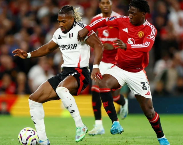 Manchester United's Kobbie Mainoo in action with Fulham's Adama Traore