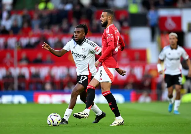 Noussair Mazraoui of Manchester United passes the ball whilst under pressure from Alex Iwobi