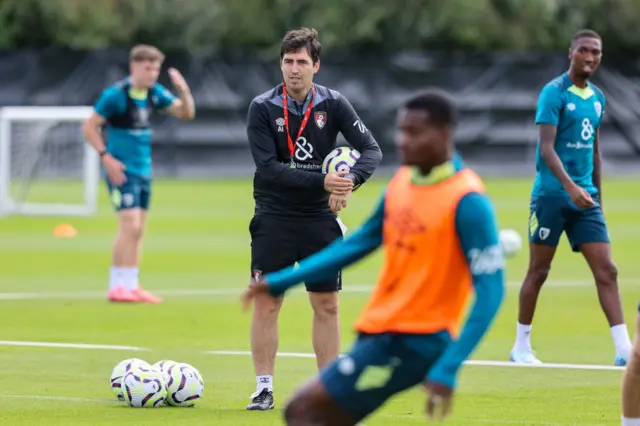 Iraola holds balls and shouts instructions in training