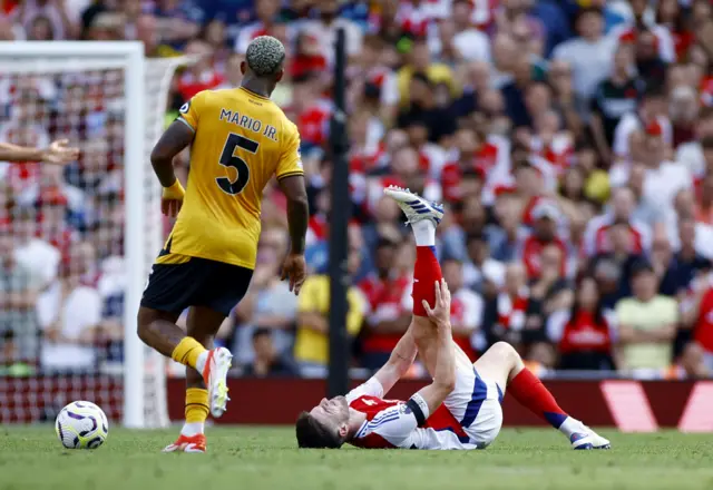 Rice holds his leg up as he suffers with cramp on the floor