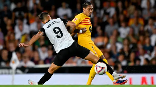 Barcelona's Raphinha in action with Valencia's Hugo Duro