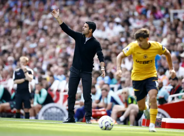 Arteta waves from his technical area